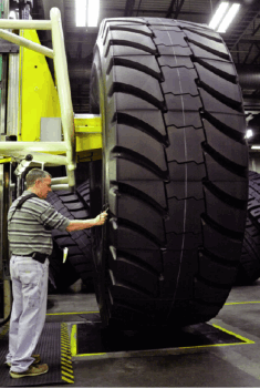 A Michelin worker puts the finishing touches on a giant earthmover tire. The company recently opened its 15th tire production plant in the U.S.